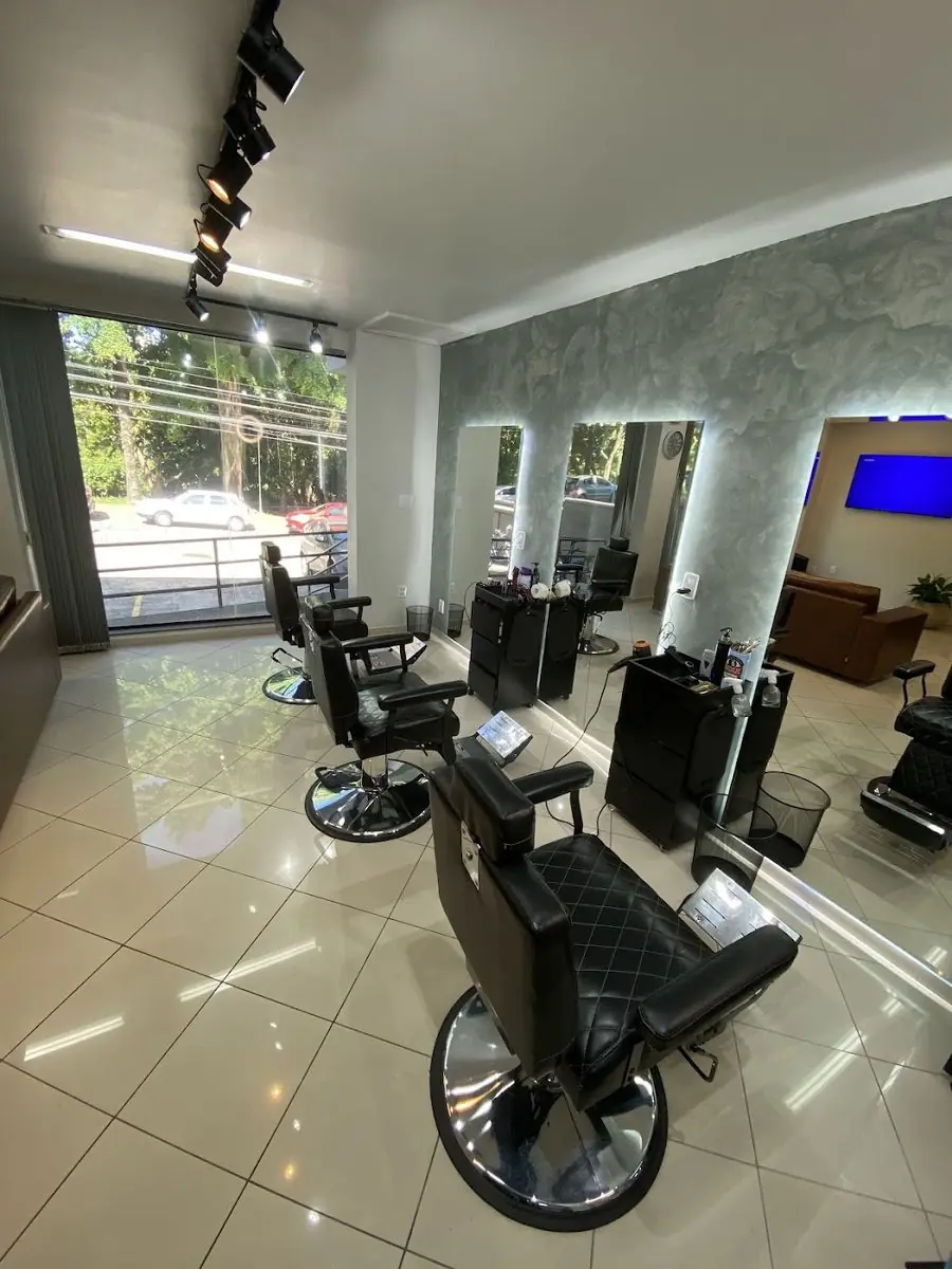 Salão da Studio 31 Barbearia com as cadeiras alinhadas e as paredes de mármore verde